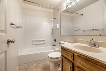 A white toilet sits in a bathroom next to a sink